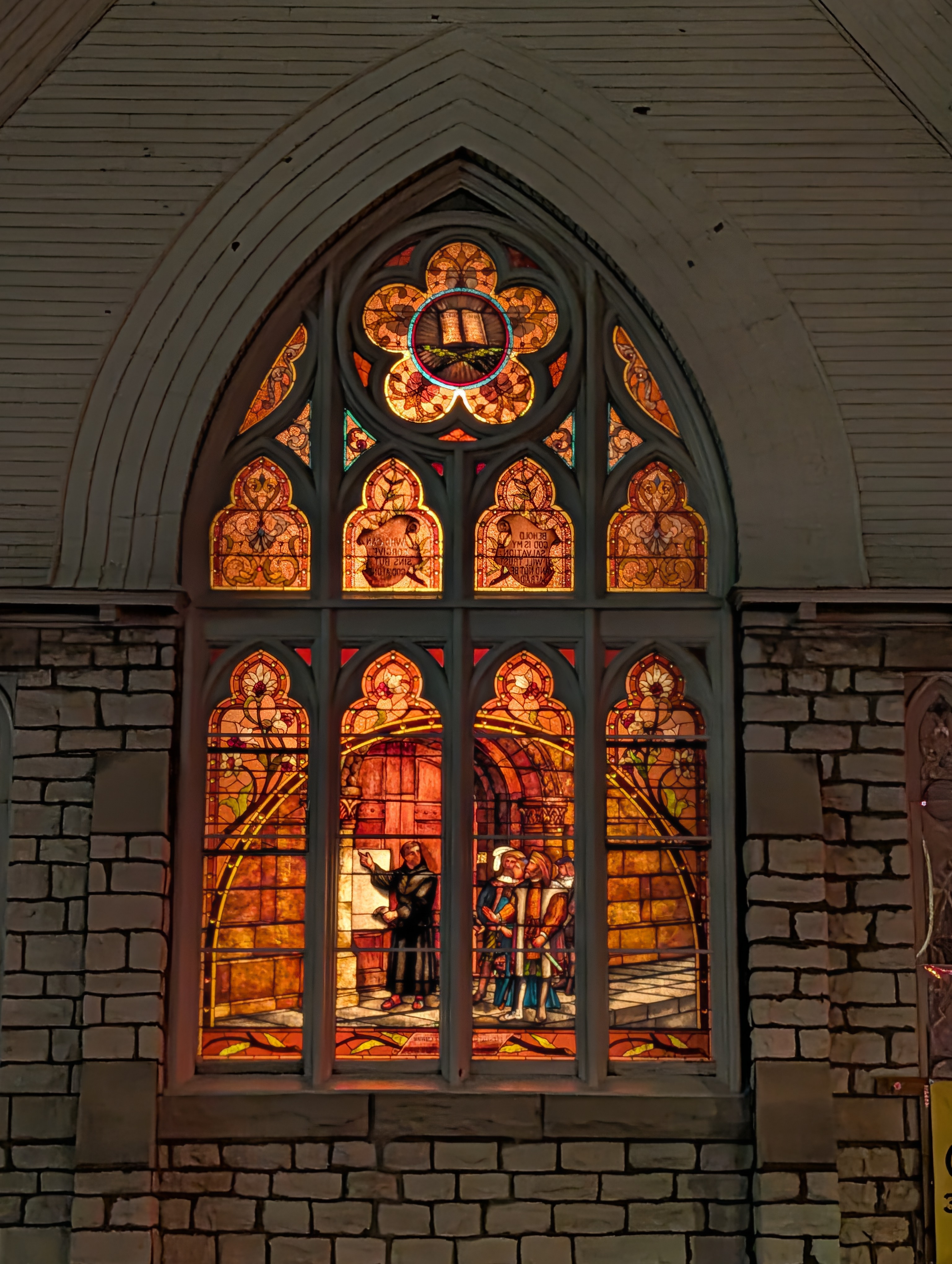 Historic stained glass illuminated at night